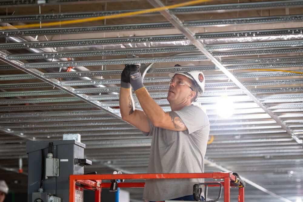 electrical worker installing wire in a building